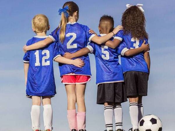 Kids huddle before playing soccer.
