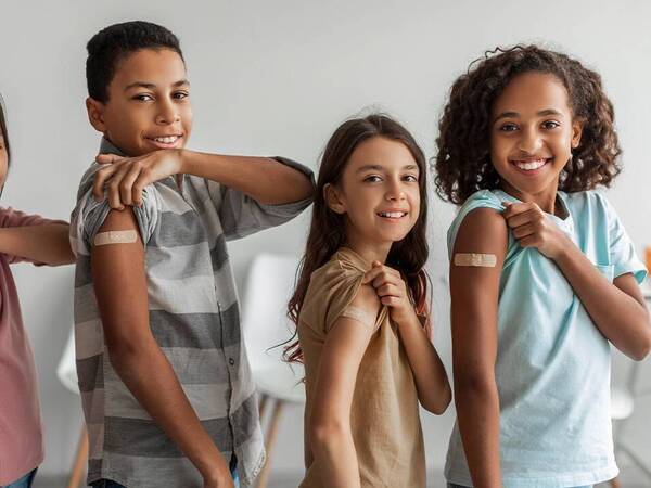 A group of kids show off their bandages as proof they received their vaccines.