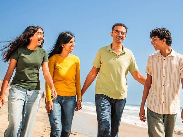 Abhi Adappa and his family laugh on the beach after Abhi, 46, recovering from surgery following a severe neck injury. 